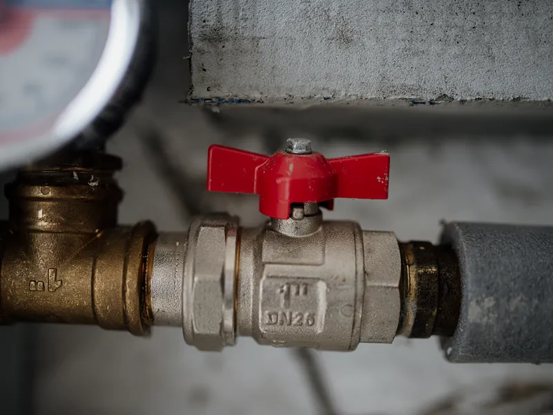 Red handled ball valve with pressure gauge on a pipe line